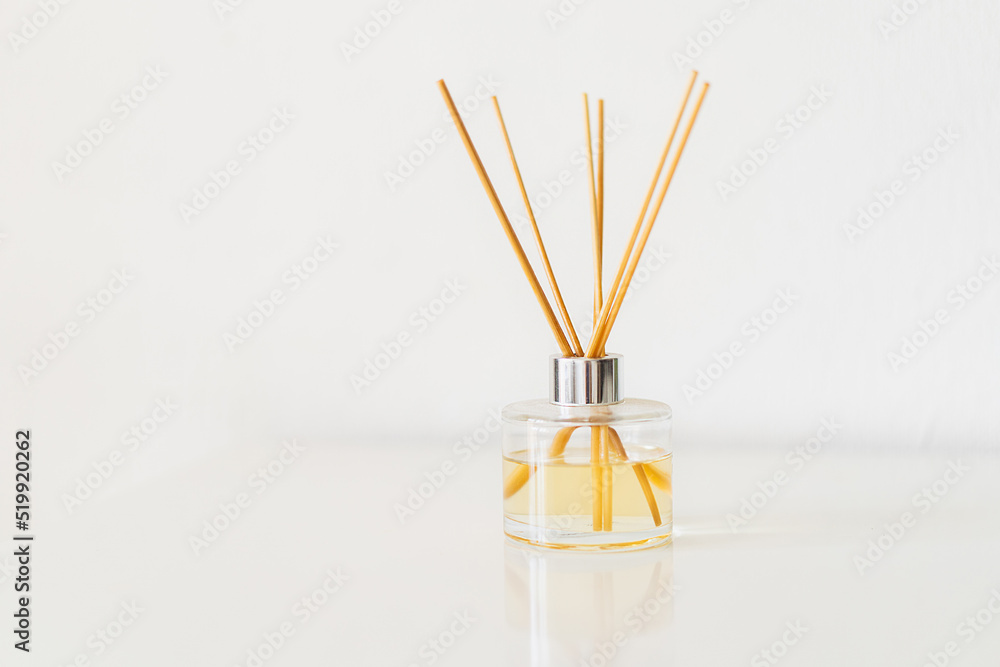 Spa therapy, aromatherapy. Diffuser bottle on a white background. Incense sticks for the home with a floral scent. The concept of eco-friendly fragrance for the home Spa therapy, aromatherapy. Diffuser bottle on a white background. Incense sticks for the home with a floral scent. The concept of eco-friendly fragrance for the home