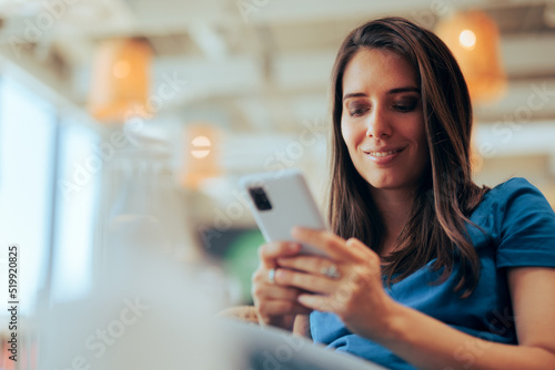 Happy Woman Holding Her Smartphone Communicating in Chat Messages. Carefree millennial girl browsing dating app smiling with confidence
