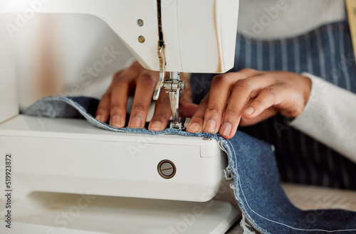 Foto Close up hands of a professional female designer sitting on a sewing machine in her studio