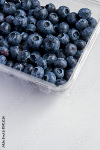 blueberries in a bowl on white table with copy space 
