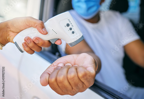 Covid, corona infection testing and scan site as a drive thru service station for people traveling. African man having his temperature taken with a thermometer before entering an airport or workplace