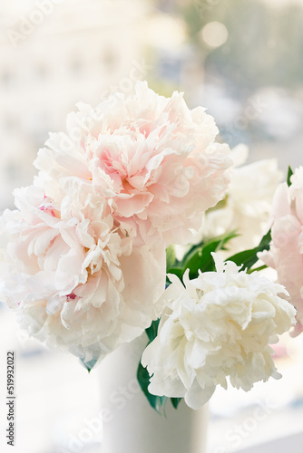 A beautiful freshly cut bouquet. Floral aesthetics. Stylish bouquet of white peonies close-up on the background of the window. A bouquet of peonies for a catalog or online store. High quality photo
