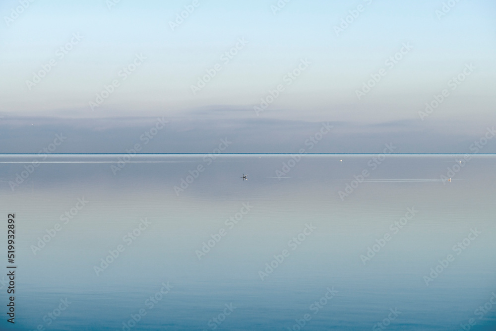 Calm, cool and relaxing front view of the ocean horizon, copy space on top. Mist over the sea on a new morning. Clear and blue sky during a tranquil dusk evening with natural background.