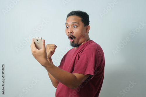 amazed reaction of man while looking phone
