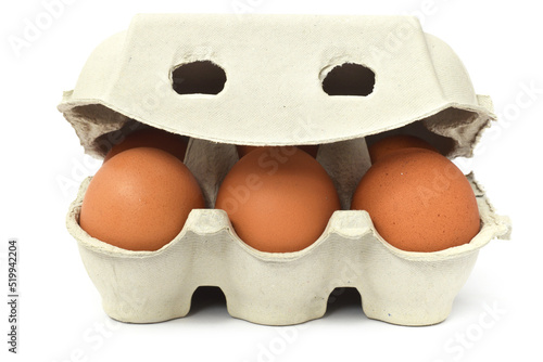 Six brown fresh raw chicken eggs in package or carton frontal isolated on white