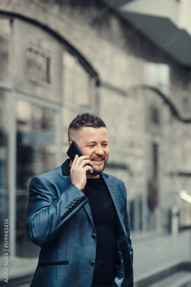 Businessman waiting for a meeting. Handsome smiling man.The businessman speaks by phone. Businessman waiting for a meeting. Handsome smiling man.The businessman speaks by phone.