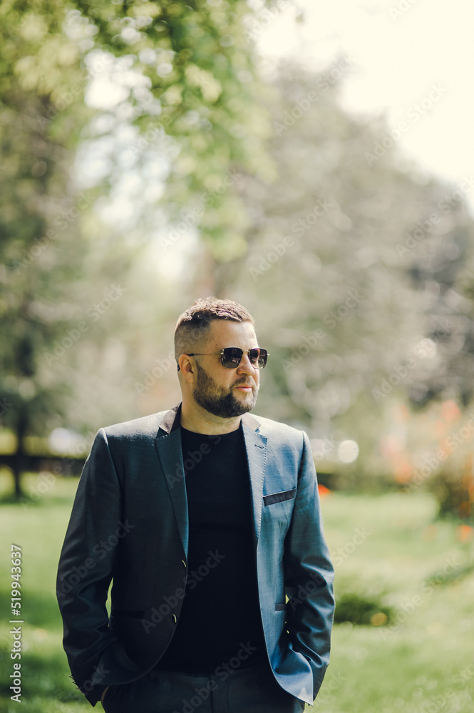 A stylish man in black glasses and a business suit is waiting for a meeting. A stylish man in black glasses and a business suit is waiting for a meeting.