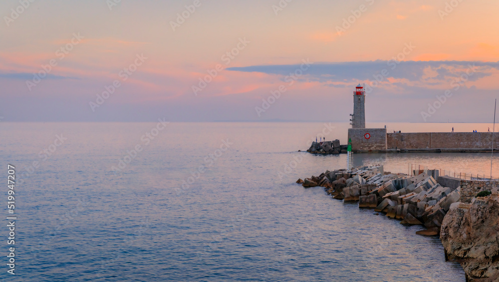 Mediterranean Sea with the lighthouse at sunset in the harbor, Nice, France