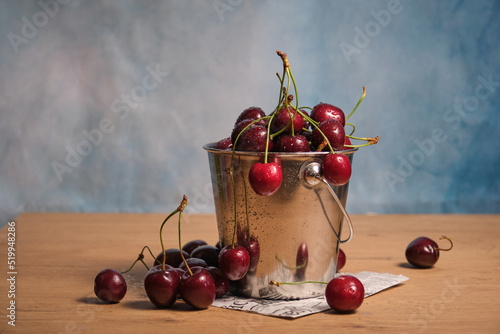 ripe cherries in a small metal bucket
