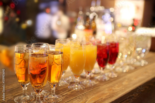 カウンターに並ぶ沢山のグラスに入った飲み物。カクテル,パーティー,会合,宴のイメージ