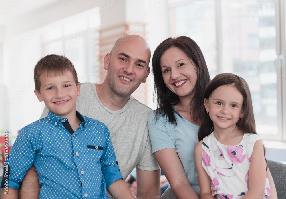 Portrait of a happy family. Photo of parents with children in a modern preschool classroom. Selective focus Portrait of a happy family. Photo of parents with children in a modern preschool classroom. Selective focus