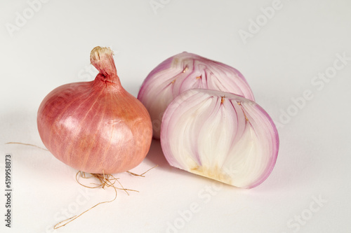 Red bulb onion and cut onion on a white background