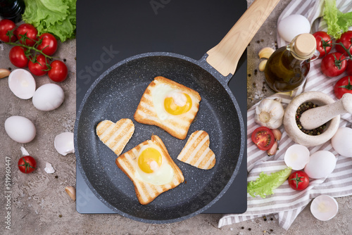 Fried egg Toasts with heart shaped holes on frying pan