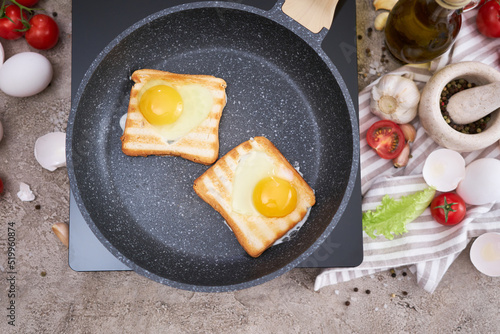 Heart shaped Fried Egg on Toast Bread in a pan at domestic kitchen