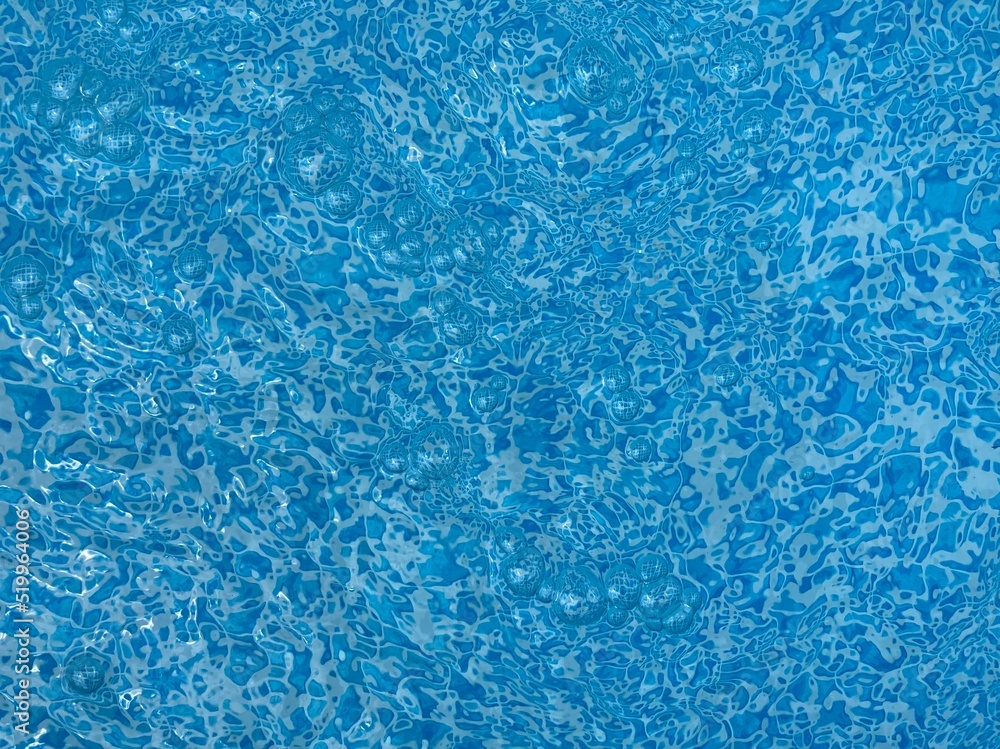 the reflecting water surface with waves in a blue pool