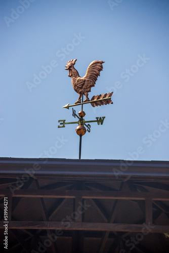 a weathercock on the top of the roof photo