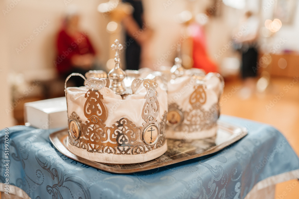 Two wedding crowns in the church. Golden crowns lie on the table in the church