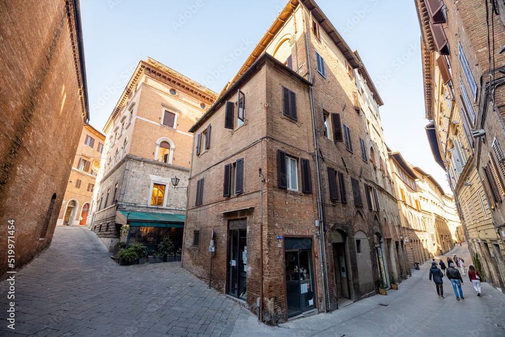View on narrow and cozy street in the old town of Siena city in Italy. Concept of ancient architecture of the Tuscan region
