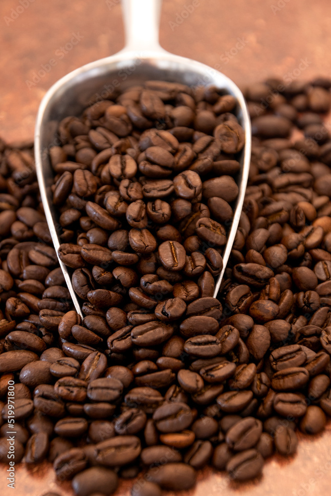 Fototapeta premium cuillère remplie de grains de café torréfié