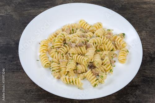 Prepared spiral pasta with chopped meat and dill on dish photo