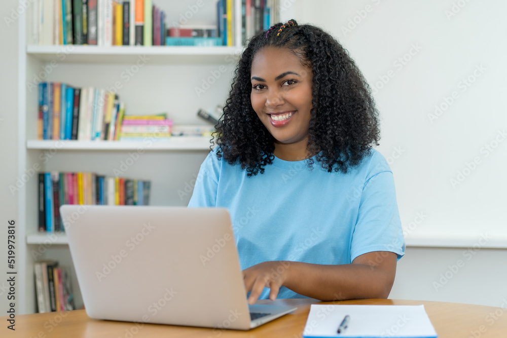 Pretty latin american female trainee working at computer Pretty latin american female trainee working at computer