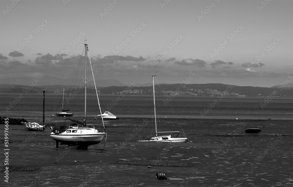Black and white photo of stuck boats at low tide