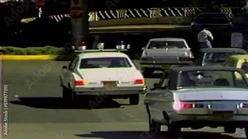 1978 POLICE CAR DRIVING IN PARKING LOT photo