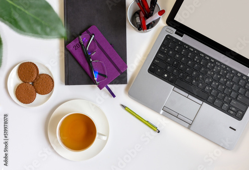 cup of tea, notebook and pen on the table