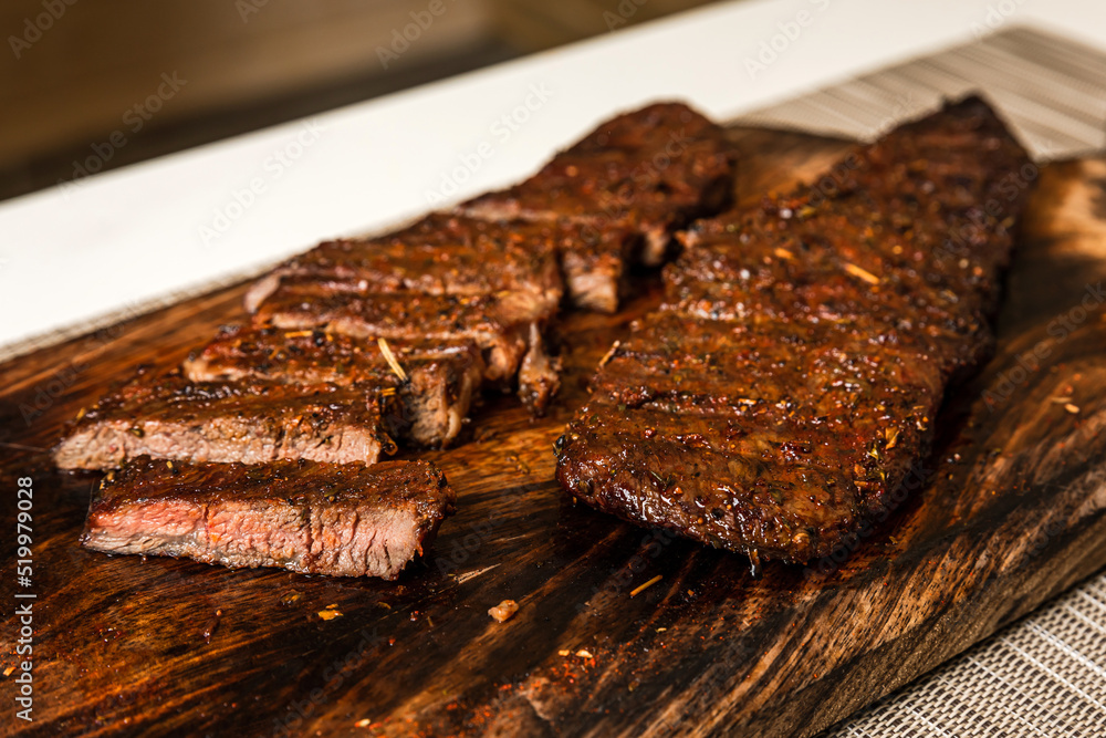 Ready to eat cooked grilled sliced piece of denver steak meat on wooden cutting board, close-up Ready to eat cooked grilled sliced piece of denver steak meat on wooden cutting board, close-up