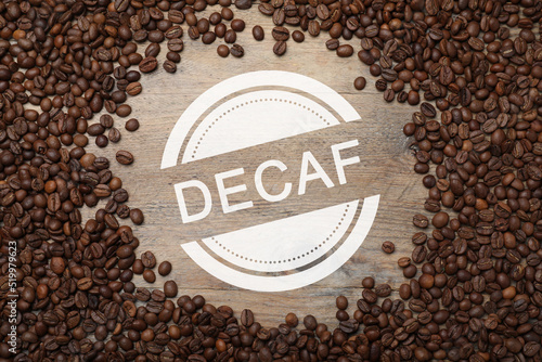 Frame of decaf coffee beans on wooden table, flat lay photo