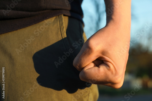 Angry man with clenched fist outdoors, closeup © New Africa