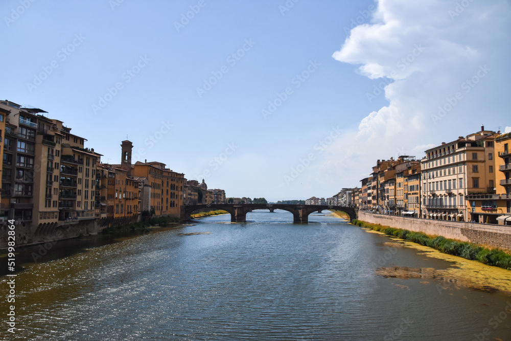 Fototapeta premium Fotografía en vertical del río de Florencia desde el Ponte Vecchio con las casas a los lados en Italia.