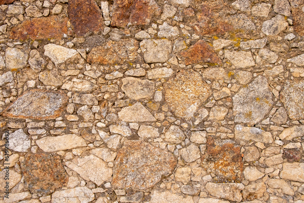 A wall built with granite stones and joined with cement. A wall built with granite stones and joined with cement.