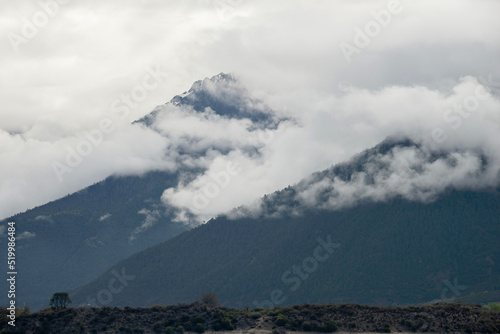 Slow moving clouds over the pine forest covered mountains
