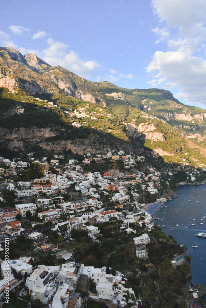 Fotografía vertical de las casas blancas del pueblo de Positano, Amalfi Coast, Italia, junto con el mar y las montañas.