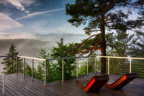 Misty sunrise on the Golden View terrace in the Jizera Mountains with a view of the Karkonosze Mountains. Poland