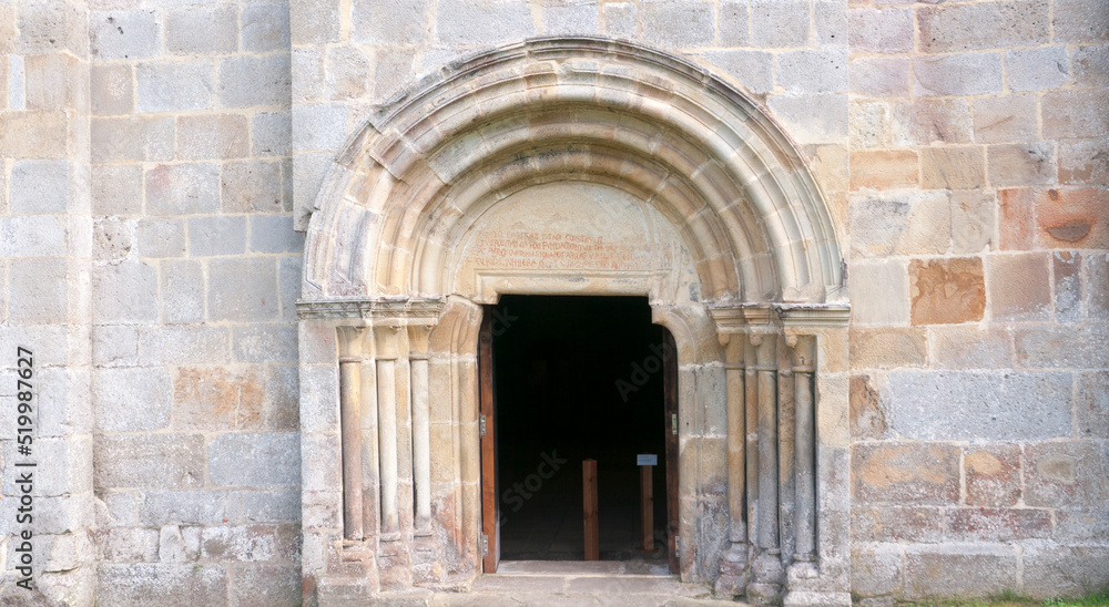 Puerta de arco de medio punto en fachada monumental de piedra