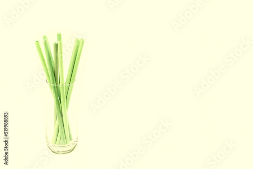 Bamboo straws in a glass against light yellow background, Plenty of space for customisation! Add your own text, logo, or graphics to create impressive presentations.