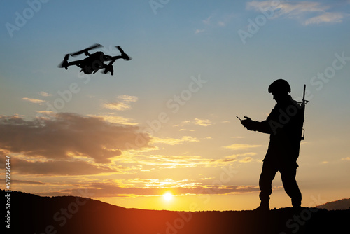 Fotografía Silhouette of soldier are using drone and laptop computer for scouting during military operation against the backdrop of a sunset
