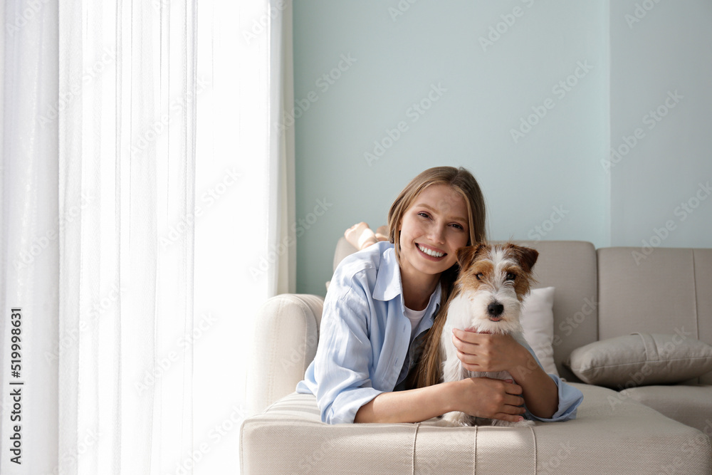 Portrait of young beautiful woman spending time with her adorable wire haired Jack Russel terrier puppy at home. Female with rough coated pup. Interior background, close up, copy space. Portrait of young beautiful woman spending time with her adorable wire haired Jack Russel terrier puppy at home. Female with rough coated pup. Interior background, close up, copy space.
