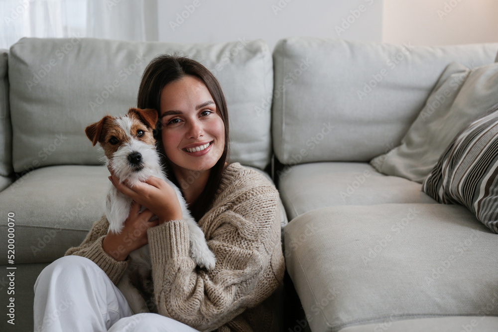 Φωτογραφία Portrait of young beautiful woman sitting on the floor with her adorable wire haired Jack Russel terrier puppy