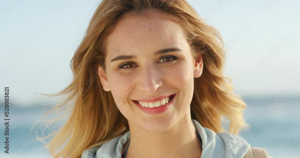 Happy, carefree and smiling woman having fun, relaxing by the beach in summer. Closeup portrait of the face of a young, joyful and beautiful female laughing and looking relaxed at the sea and seaside Happy, carefree and smiling woman having fun, relaxing by the beach in summer. Closeup portrait of the face of a young, joyful and beautiful female laughing and looking relaxed at the sea and seaside