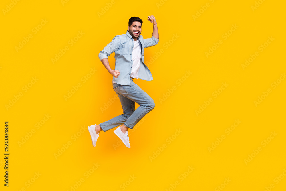 Full body photo of attractive hispanic young guy celebrate job promotion wear stylish jeans clothes isolated on yellow color background