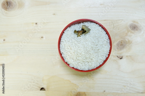 Healthy food. red ceramic bowl with high carb rice on wooden background. Top view, high resolution product.