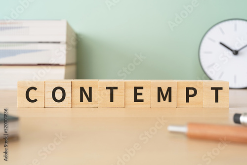 軽蔑・侮辱罪のイメージ｜「CONTEMPT」と書かれたブロックが置かれたデスク
 photo