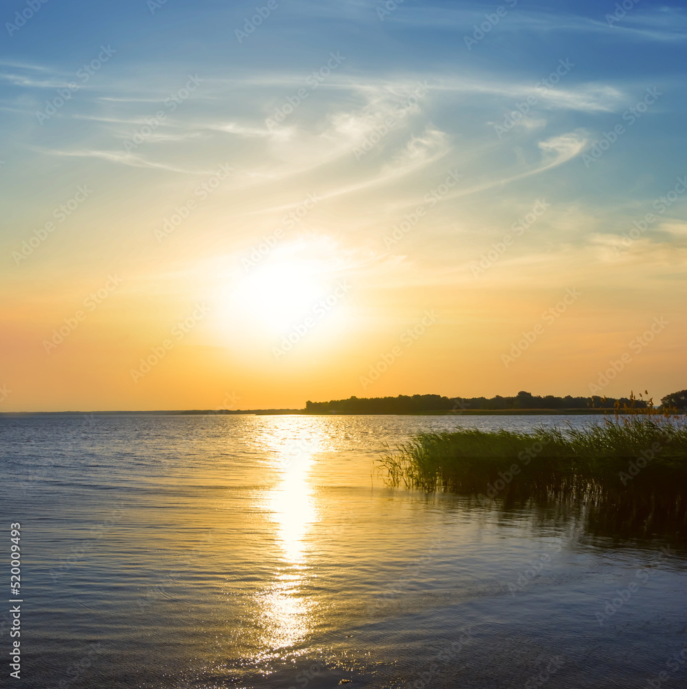 calm lake coast at the dramatic sunset, natural summer outdoor scene