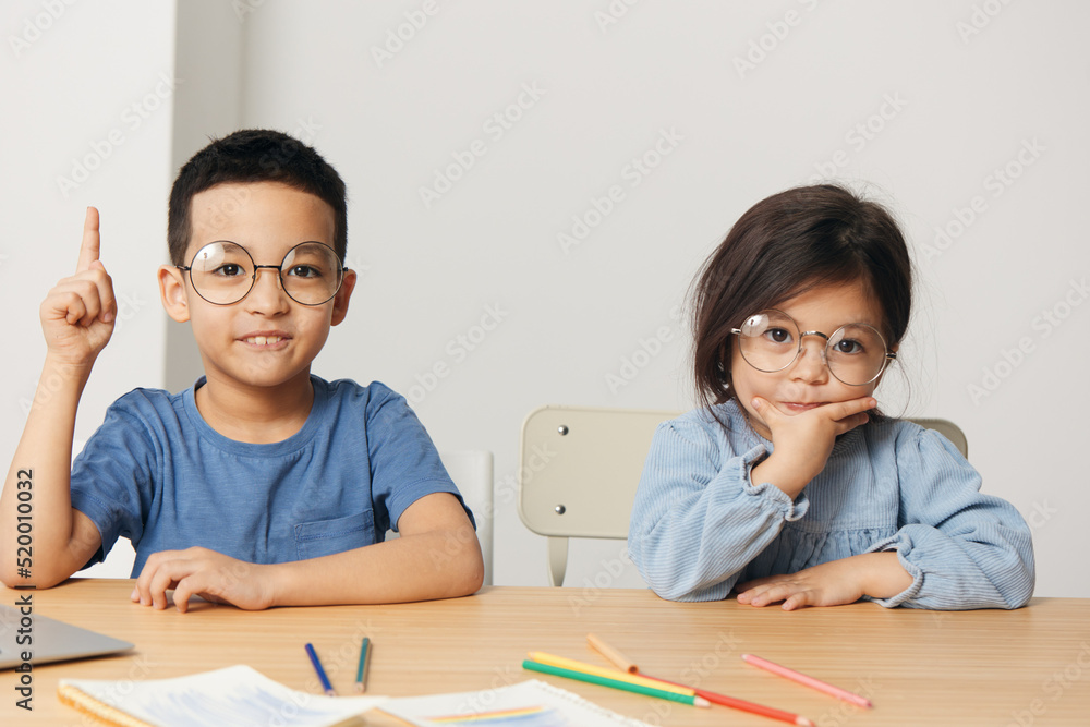 happy little boy and girl sitting at the lesson happy little boy and girl sitting at the lesson
