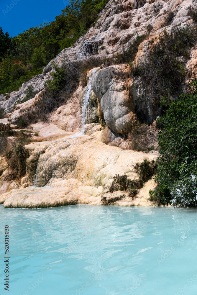 Outdoors natural spa thermal in Italy with bath pool and waterfall.