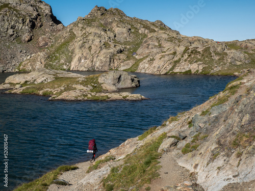Woman hiking at the Domenon lake in Belledonne Moutains, Alpes, France