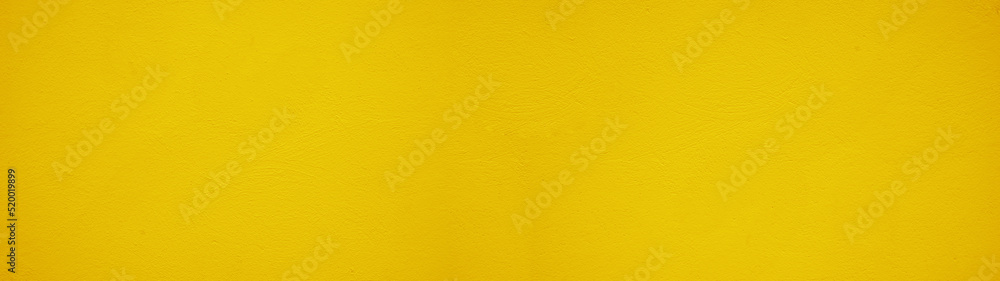 Abstract yellow colored painted rough plaster facade texture background banner panorama. Abstract yellow colored painted rough plaster facade texture background banner panorama.